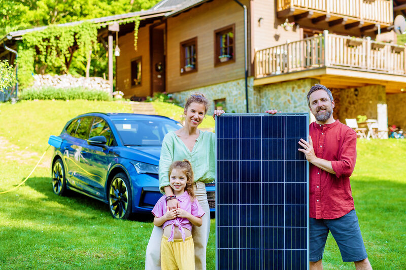 Happy Family Posing With Photovoltaics Panel During Their Electric Car Charging.