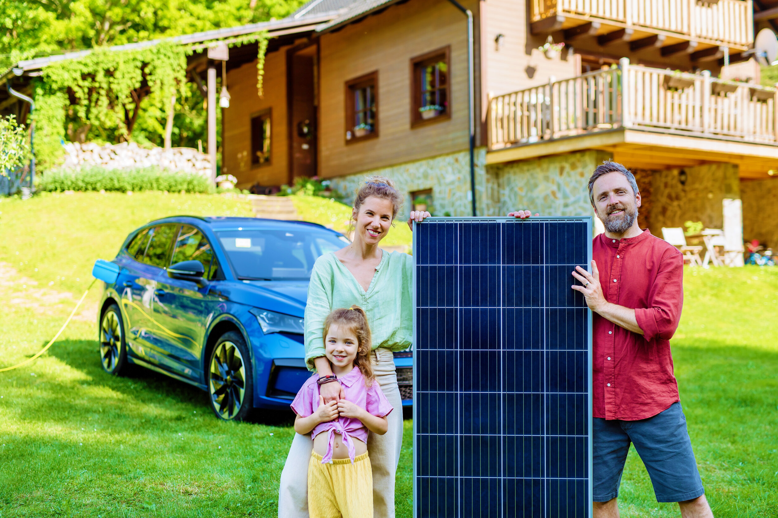 Happy Family Posing With Photovoltaics Panel During Their Electric Car Charging.